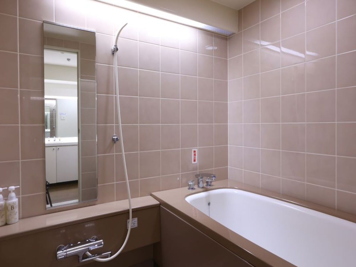 A bathroom with a bathtub, a shower, a sink, and a mirror.