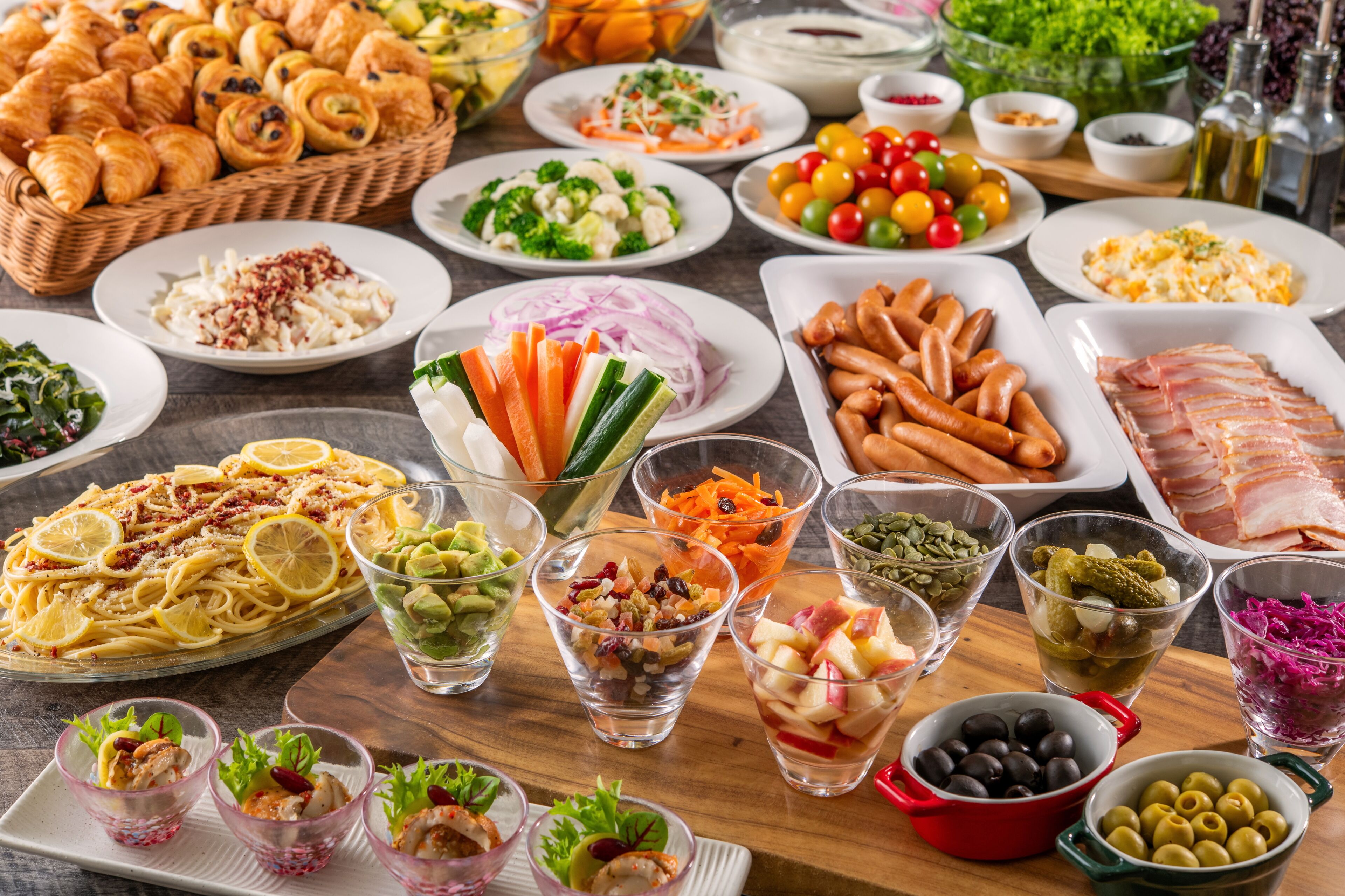 A variety of food items including pasta, salads, and meats arranged on a table.