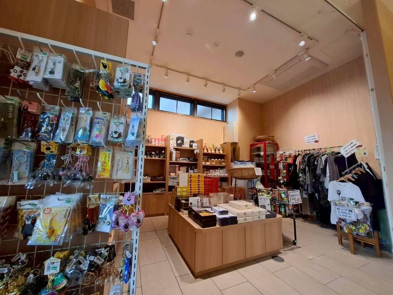 Uma loja com prateleiras de mercadorias, um cabideiro e um balcão de exposição.
