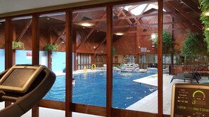An indoor swimming pool with wooden beams and a view of the pool area through large windows. - Macdonald Spey Valley Resort (Aviemore)