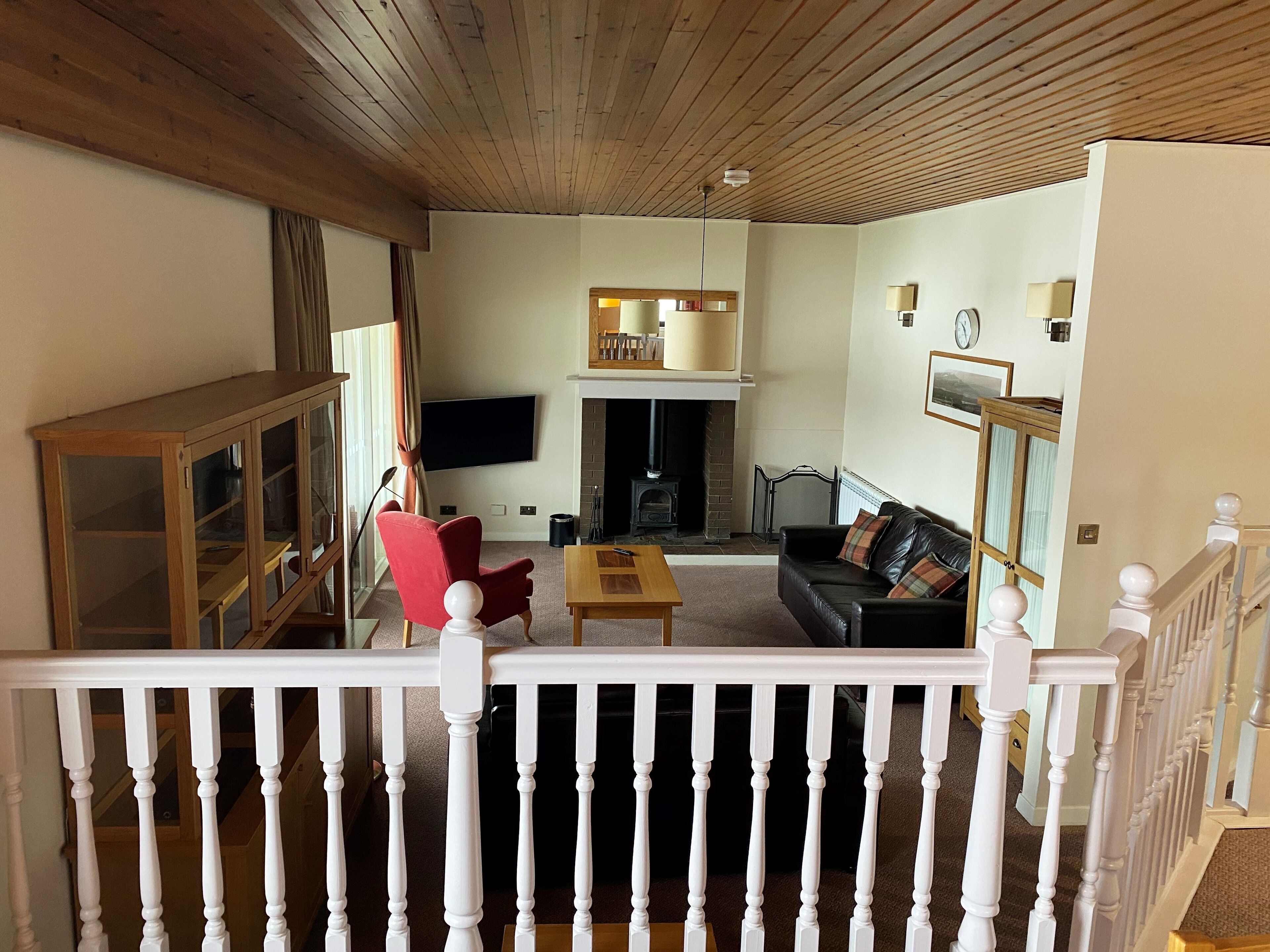 A living room with a fireplace, a television, and a staircase.