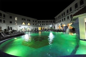 Una piscina al aire libre, sillones reclinables de piscina