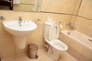 A bathroom with a sink, toilet, and bathtub.