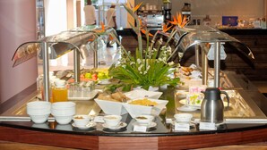 A buffet with various food items and a coffee station.