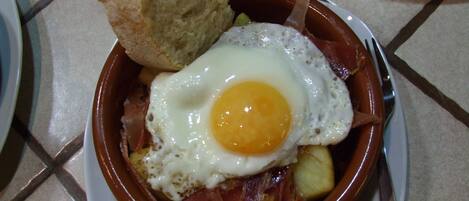 A plate with a fried egg, ham, and a biscuit.