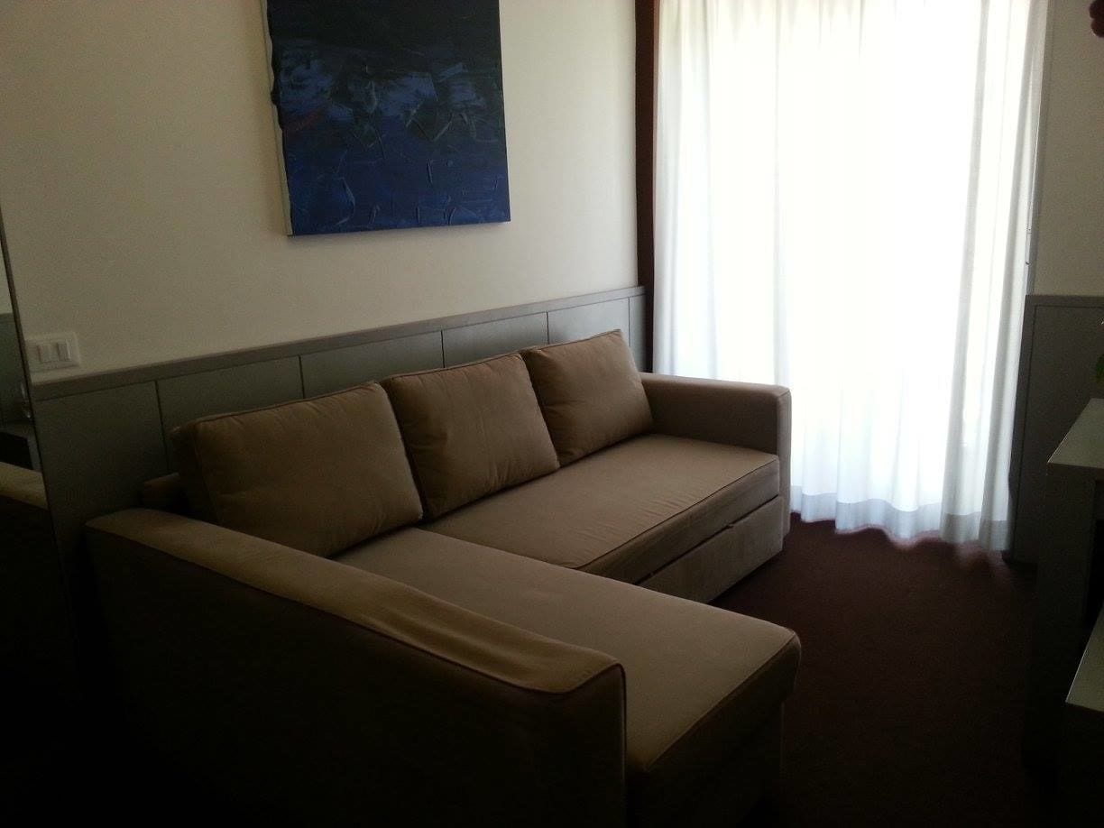 Una sala de estar moderna con un sofá y un televisor de pantalla plana.