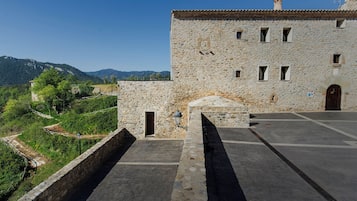 A stone building with a tiled roof, a door, and a small window.