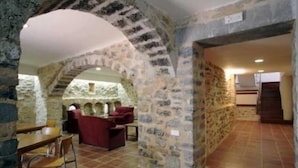 A stone-walled room with a dining area and seating. - Ligueerre Resort (Abizanda)