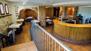 A restaurant with a stone wall, wooden counter, and tiled flooring. - Ligueerre Resort (Abizanda)