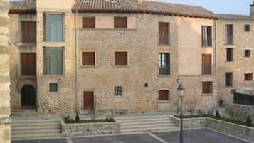 Un edifici de pedra amb diverses finestres i un teulat de rajoles.