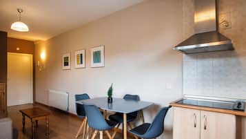 Una cocina moderna con estufa integrada, campana de acero inoxidable y un comedor con mesa y sillas.