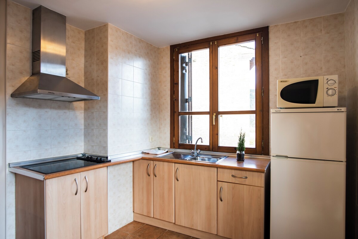 A kitchen with a stove, sink, and microwave.