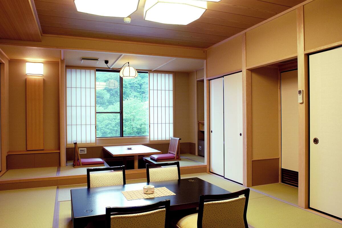 A traditional Japanese room with tatami flooring, a low table, and sliding doors.