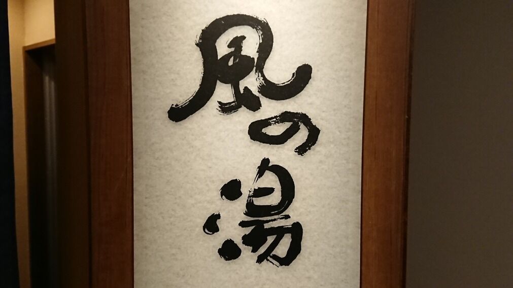 A vertical calligraphy sign on a wall.