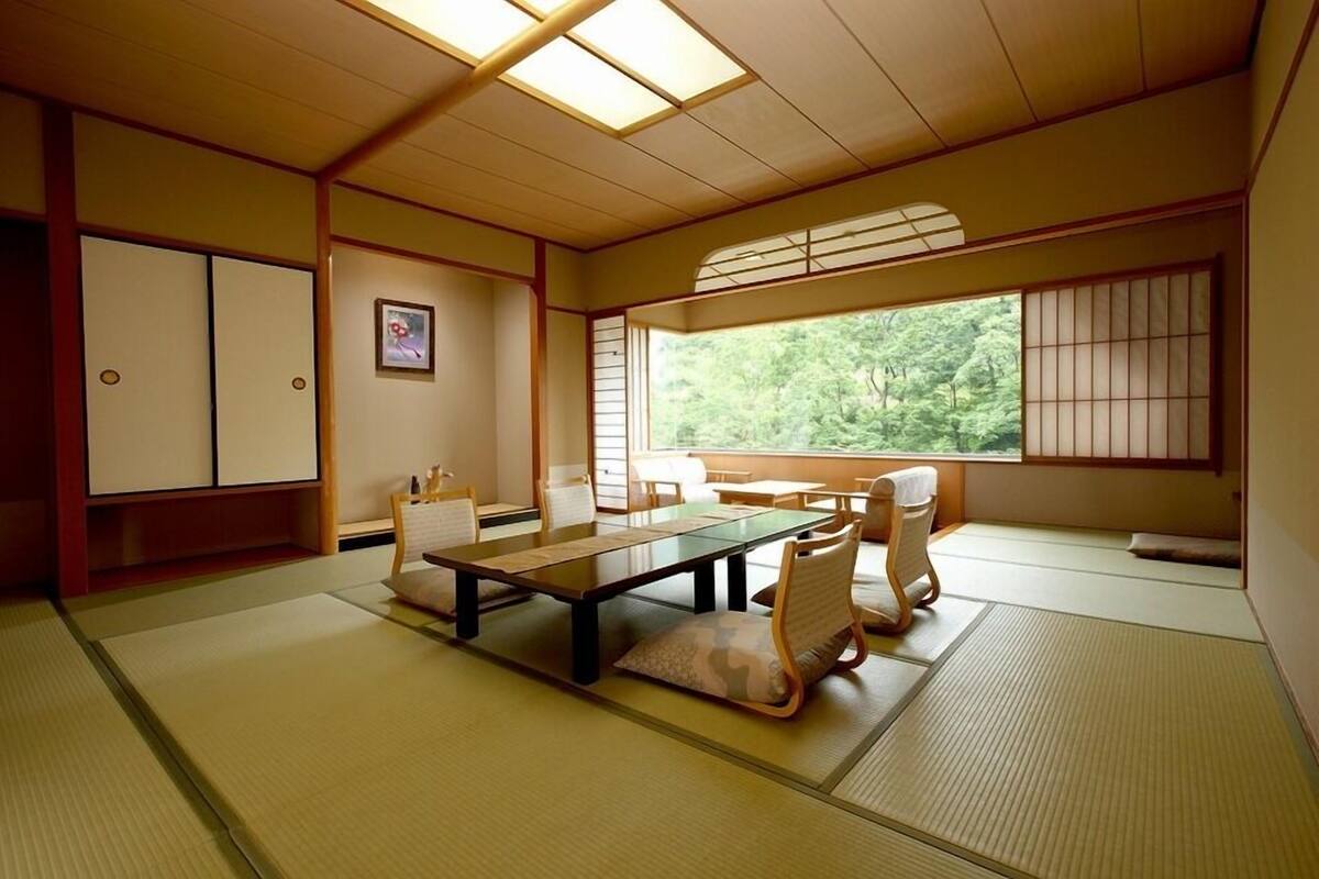 A traditional Japanese room with tatami flooring, a low table, and sliding doors.