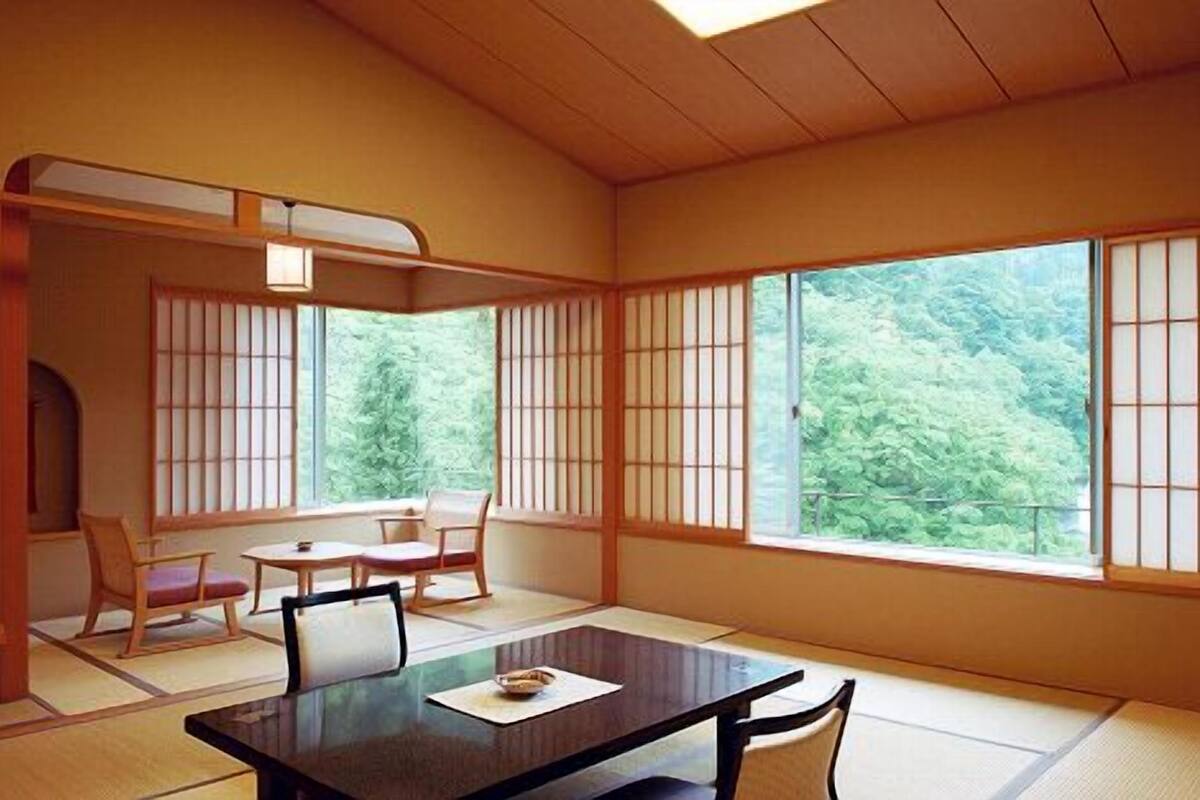 A traditional Japanese room with tatami flooring, a low table, and sliding shoji doors.