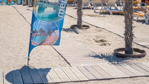 En strand med et blåt banner, der reklamerer for Mera Hotels Resorts.