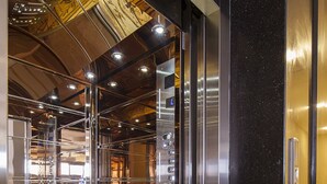 Elevatorinteriør med spejlbund og metalvægge.