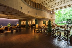 A spacious lobby with a curved ceiling, multiple seating areas, and a view of the outdoors. - Hokkaido Hotel (Obihiro)