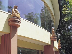 A building with a curved facade and a series of stone statues on the exterior. - Hokkaido Hotel (Obihiro)