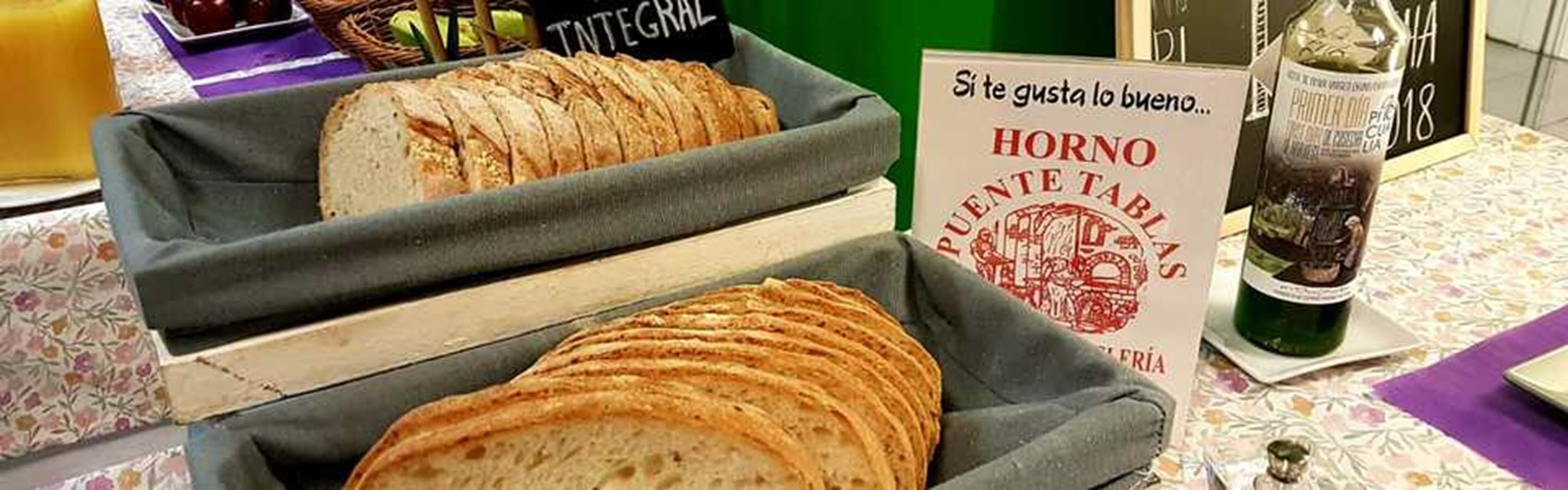 A bread display with a sign that reads "HORNO PUENTE TABLA".