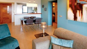 Un salon moderne comprenant un canapé, une table basse et un coin repas avec des chaises et une table.