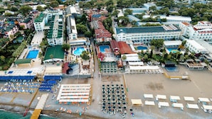 An aerial view of a resort with multiple buildings, a beach area with sun loungers, and a swimming pool. - Aleria Belport Beach Hotel - All inclusive (Kemer)
