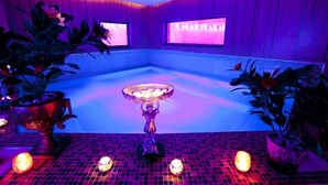A room with a central hot tub, surrounded by potted plants, and a tiled floor. - Aleria Belport Beach Hotel - All inclusive (Kemer)