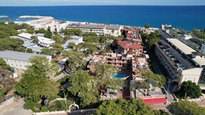 An aerial view of a coastal hotel with multiple buildings, a swimming pool, and a marina. - Aleria Belport Beach Hotel - All inclusive (Kemer)