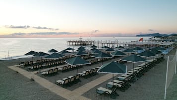 Playa privada, sillas reclinables de playa, sombrillas