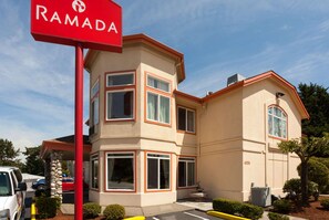 Un immeuble à plusieurs étages, sur lequel on peut lire l’inscription rouge « RAMADA ».