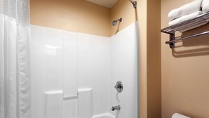 Une salle de bain avec douche, toilettes et porte-serviettes.