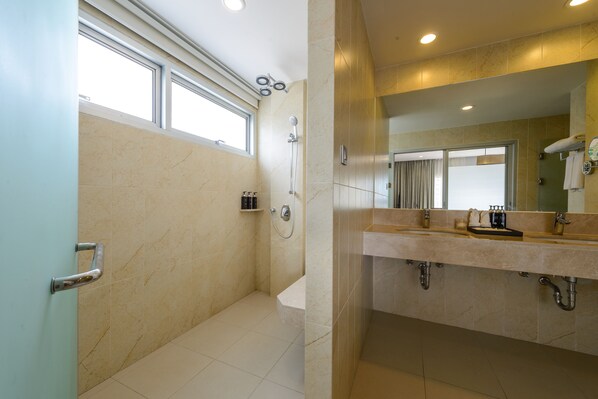 Un baño moderno con ducha, bañera y tocador con espejo.