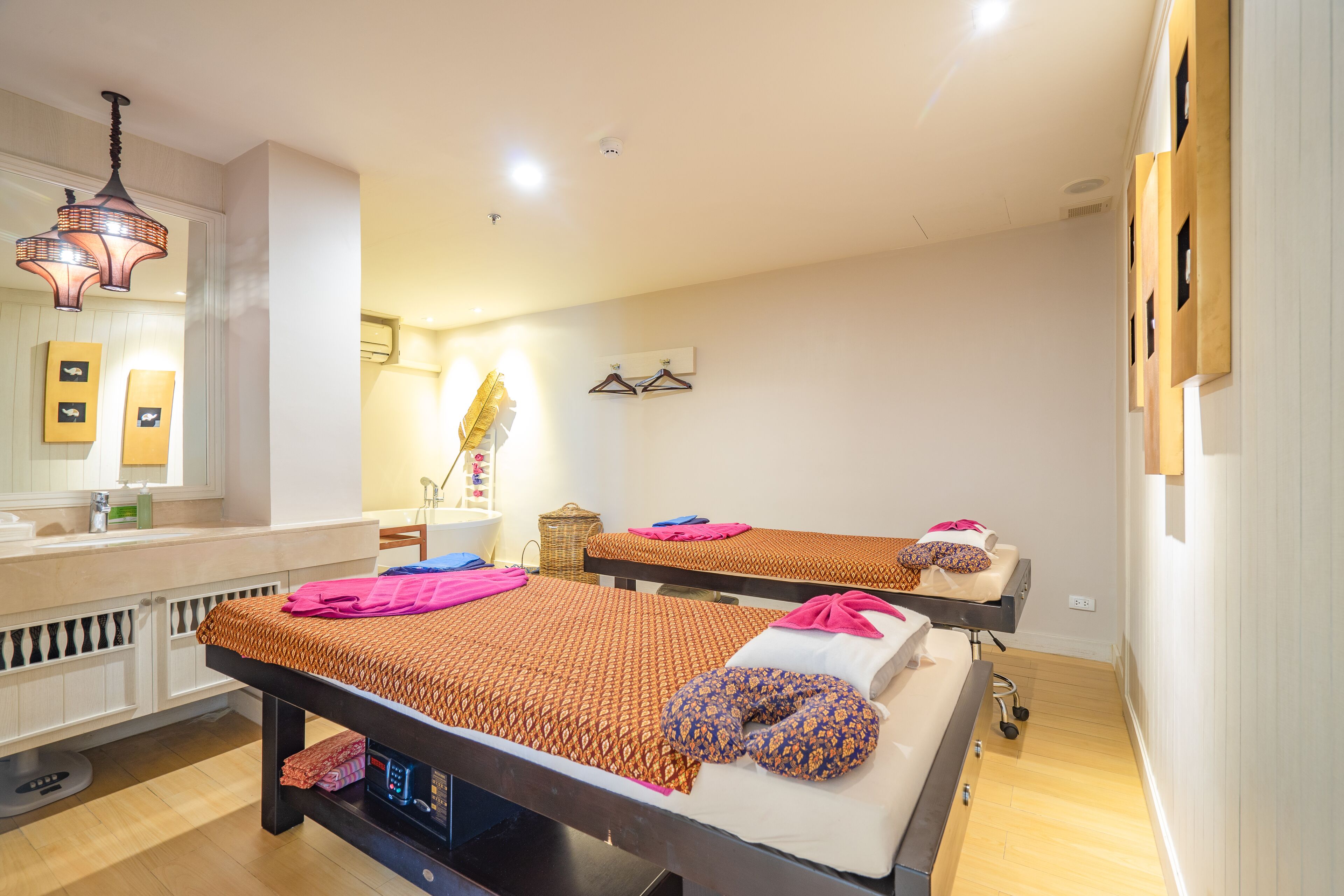 A hotel room with two beds, a bathroom, and a small sitting area.