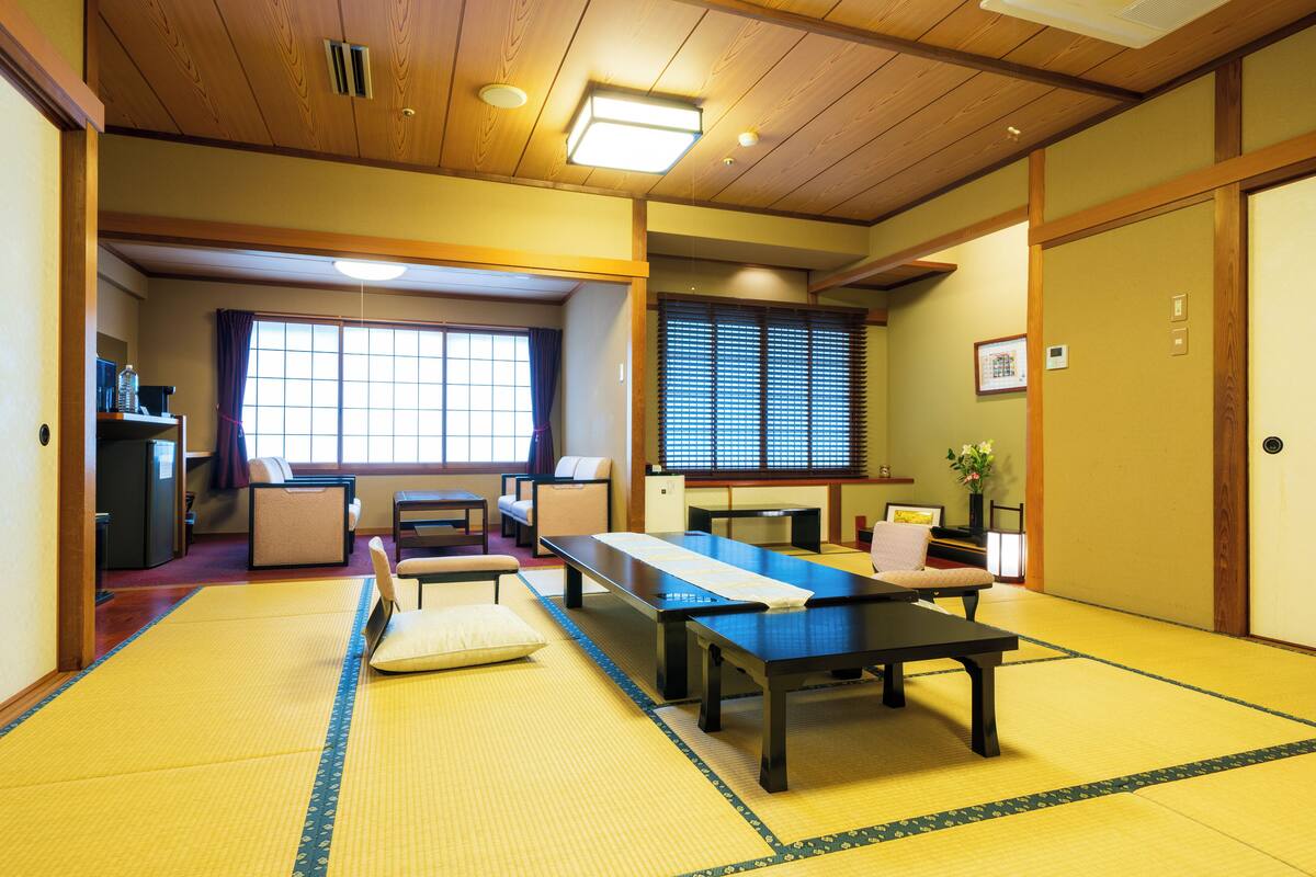 A traditional Japanese room with tatami flooring, a low table, and a sofa.