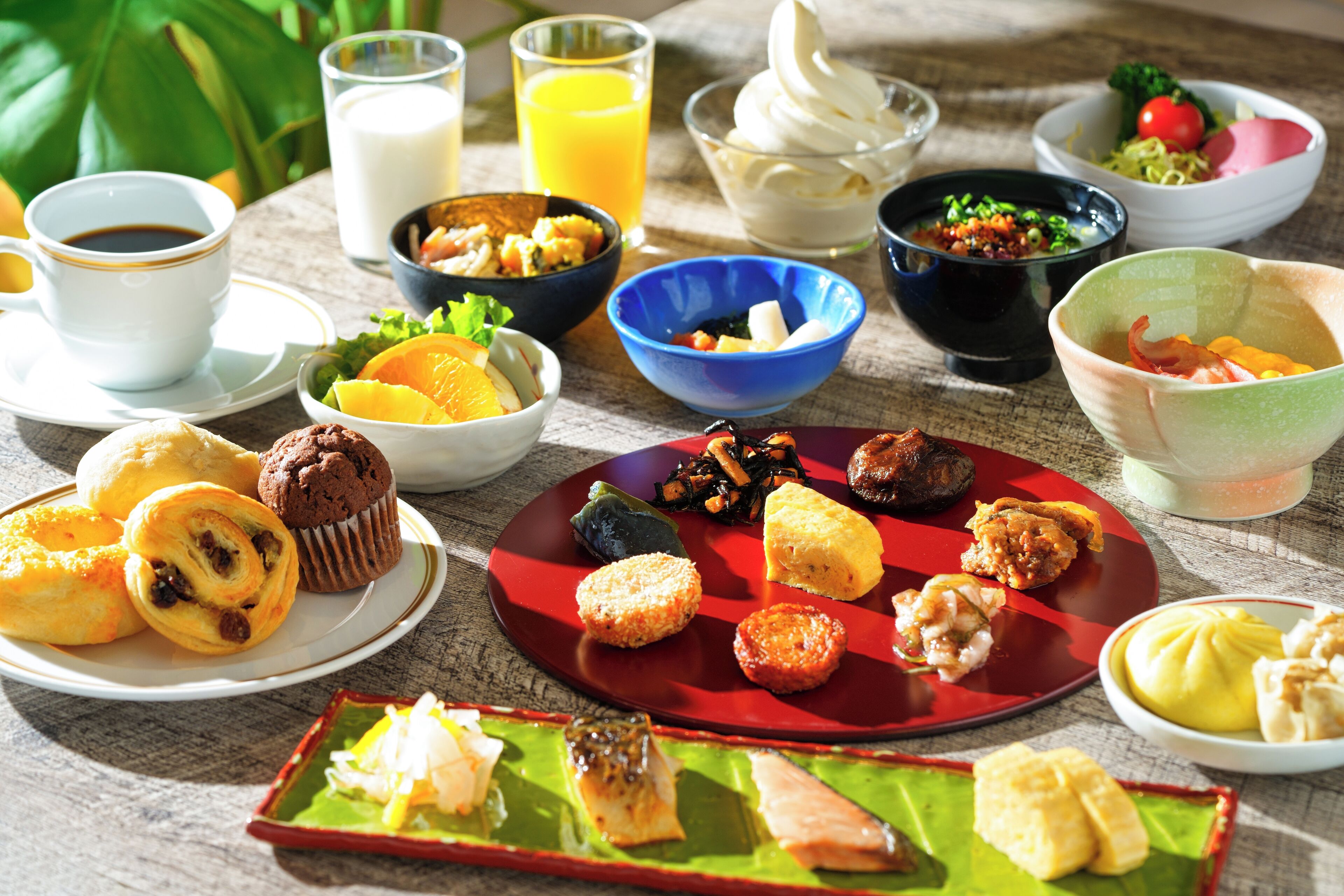 A variety of breakfast items including pastries, fruits, and beverages on a wooden table.