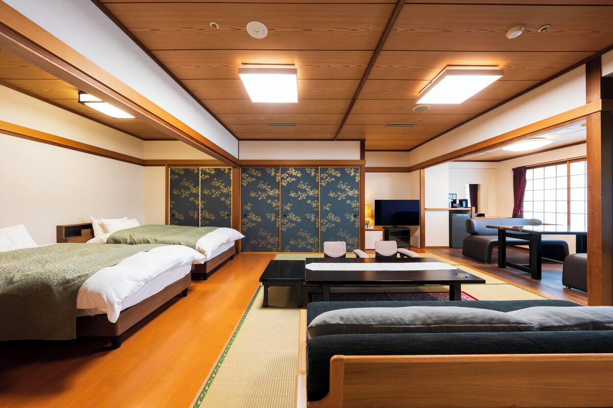 A traditional Japanese-style room with tatami flooring, a futon bed, a low table, and a sliding door.