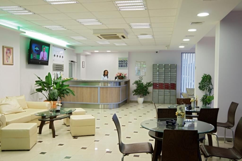 A reception area with a counter, seating, and a television screen.