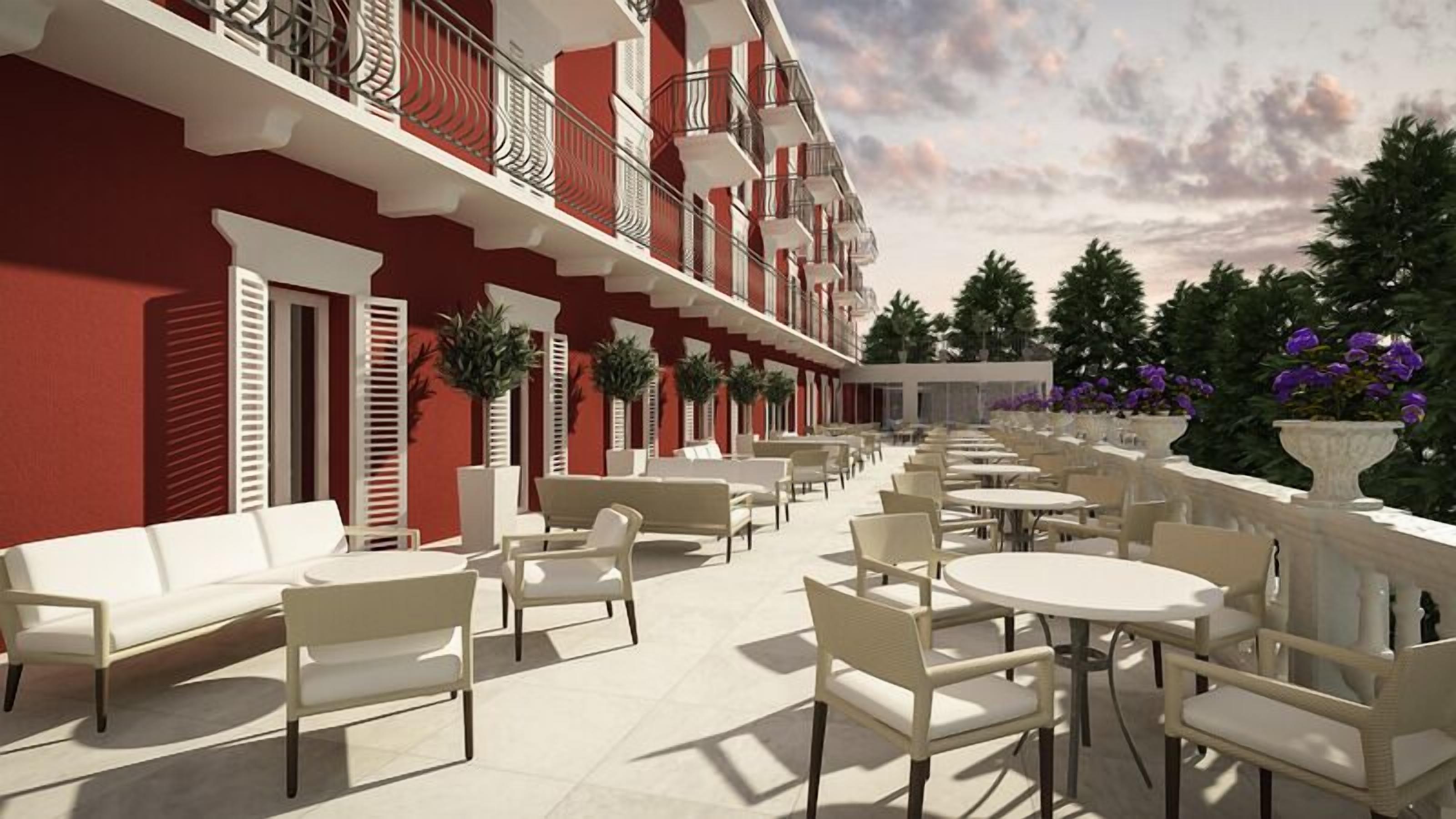 An outdoor seating area with white furniture and a red building facade.