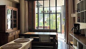 Una cuina amb taula de dinar, armaris de fusta i vista per la finestra.
