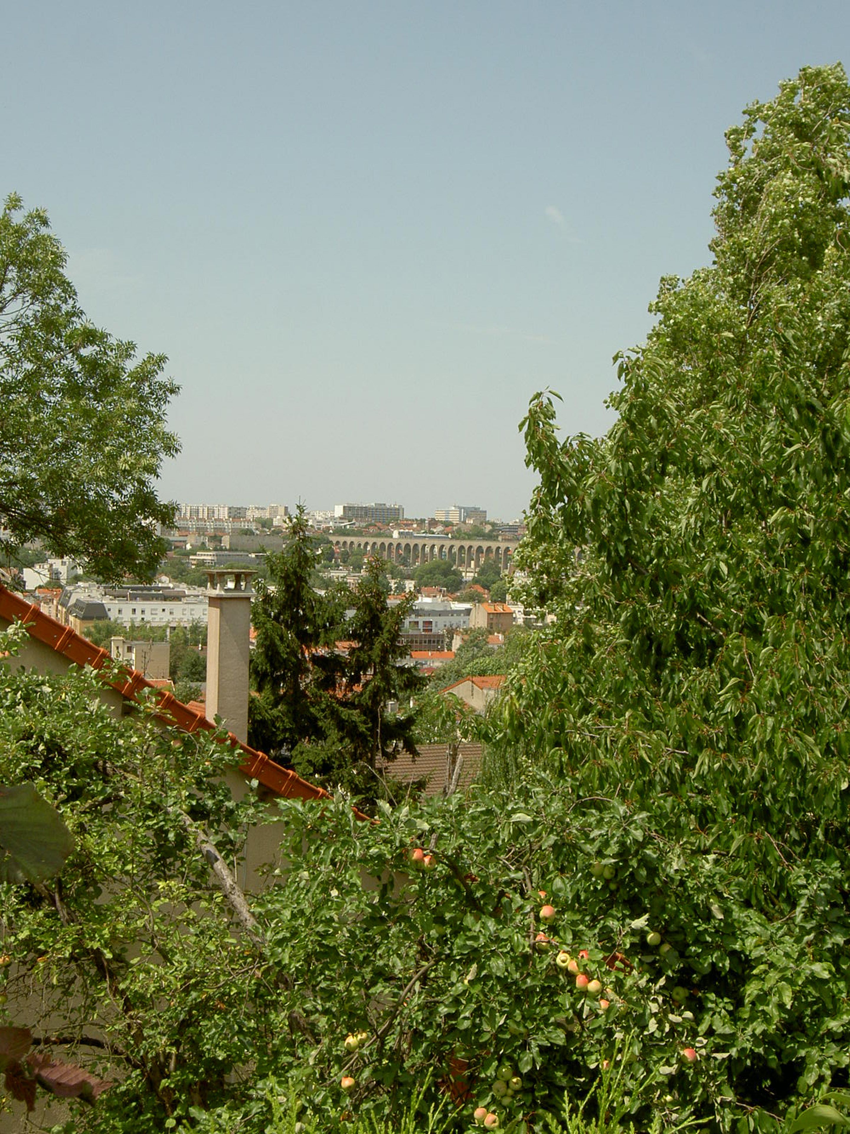 Une vue d’une ville avec ses bâtiments et un pont en arrière-plan.