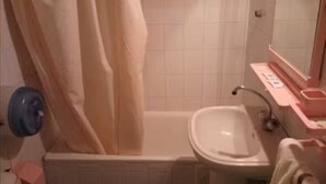A bathroom with a bathtub, a sink, and a mirror. - Frantz Fanon (Setif)