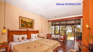 Un bungalow de luxe doté de deux lits, d’un tableau, d’un coin repas et offrant une vue sur l’extérieur.