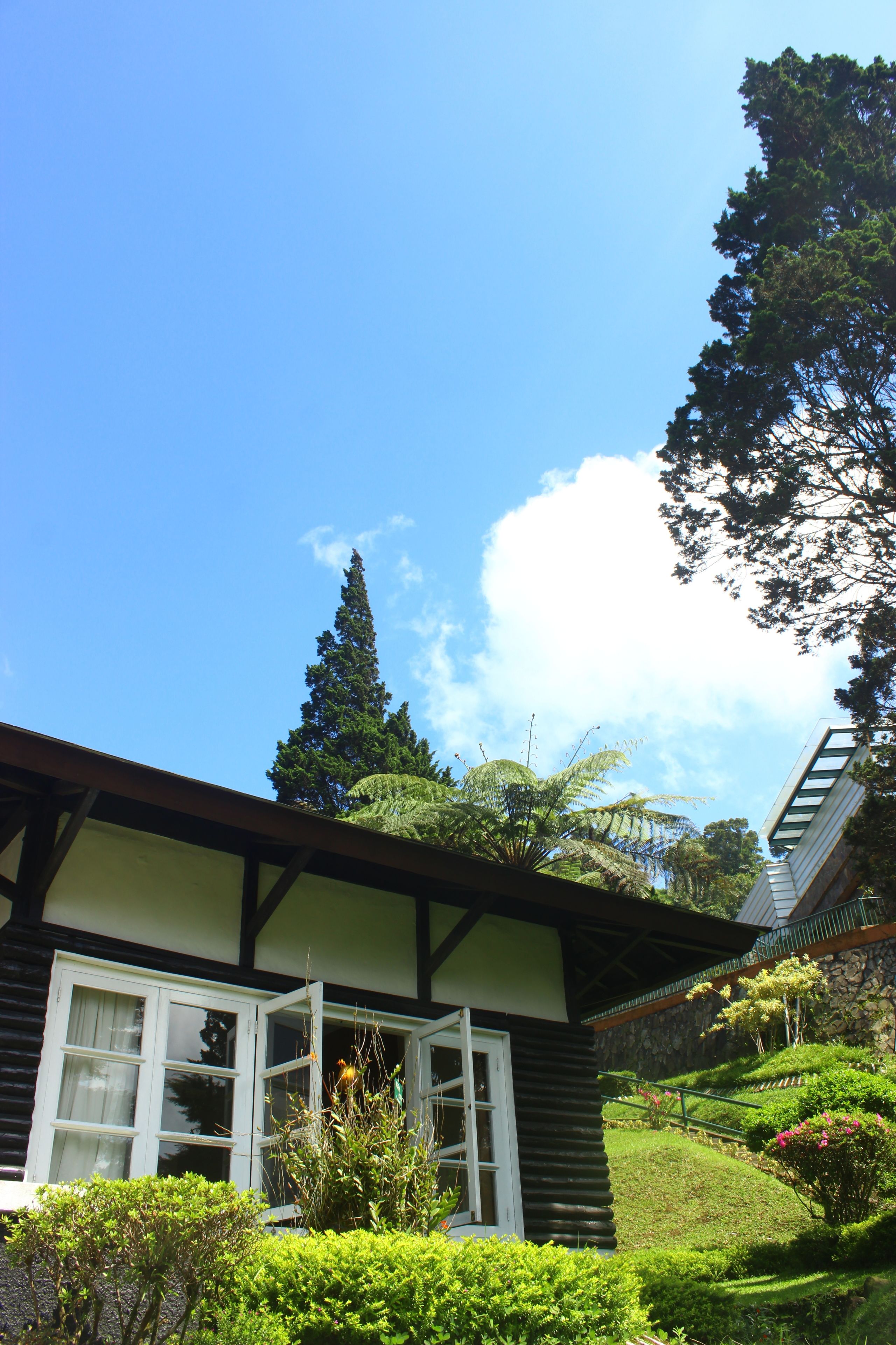 A traditional building with a sloped roof, wooden beams, and a window with white shutters.