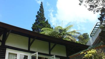 A traditional building with a sloped roof, wooden beams, and a window with white shutters.