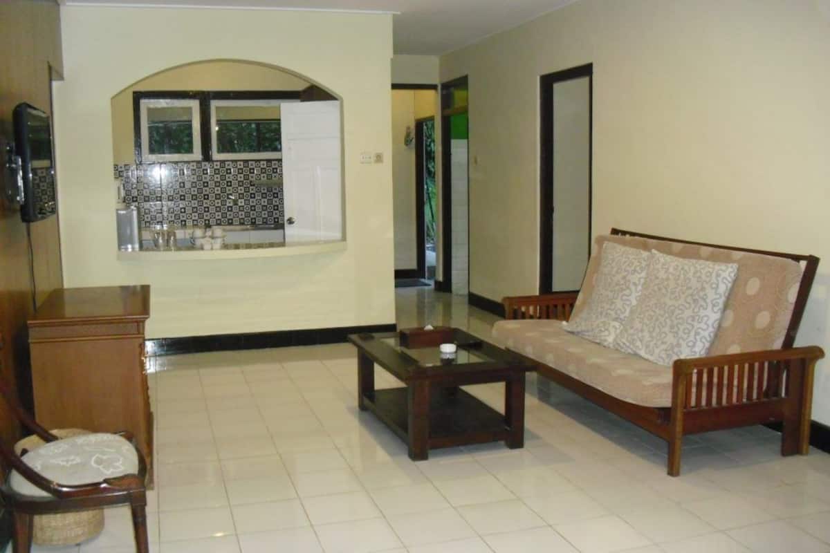 A living room with a sofa, a wooden coffee table, and a chair.