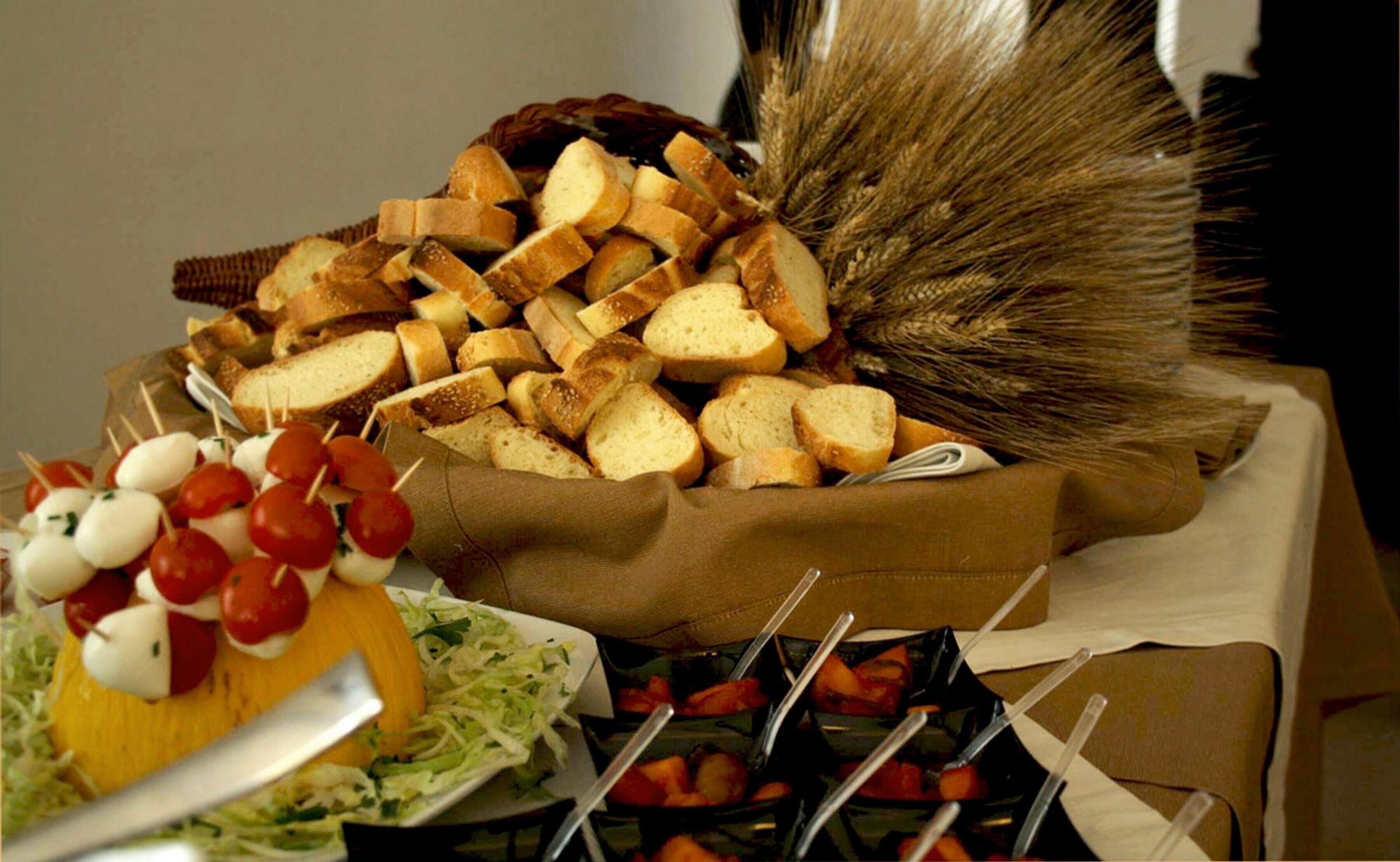 A buffet table with various food items including bread, cheese, and vegetables.