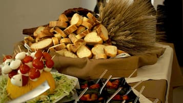 A buffet table with various food items including bread, cheese, and vegetables.