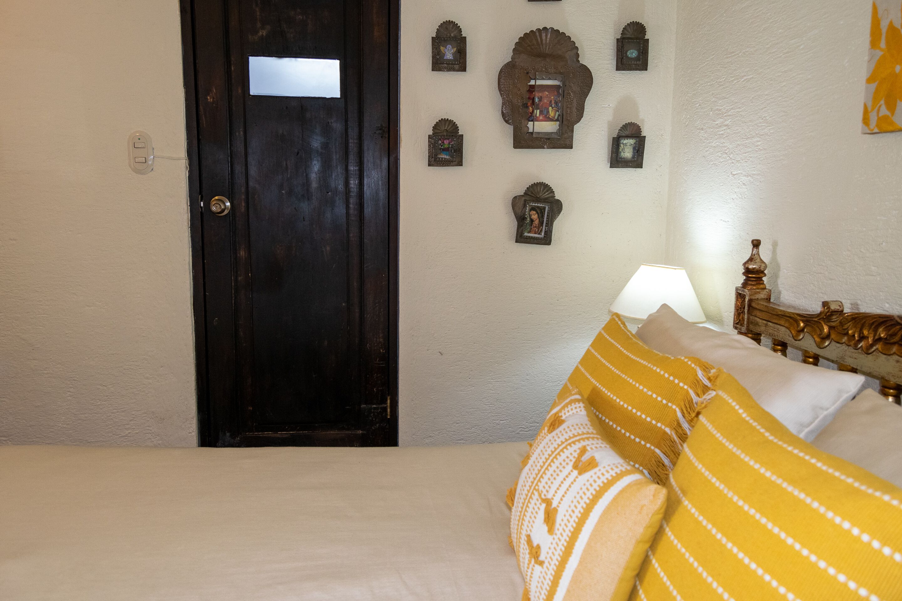 Un dormitorio con cama, puerta de madera y adornos en la pared.