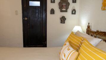 Un dormitorio con cama, puerta de madera y adornos en la pared.